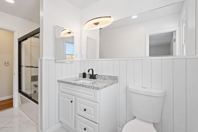 full bathroom featuring vanity, enclosed tub / shower combo, and toilet