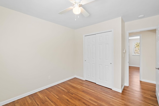 unfurnished bedroom with light hardwood / wood-style floors, a closet, and ceiling fan