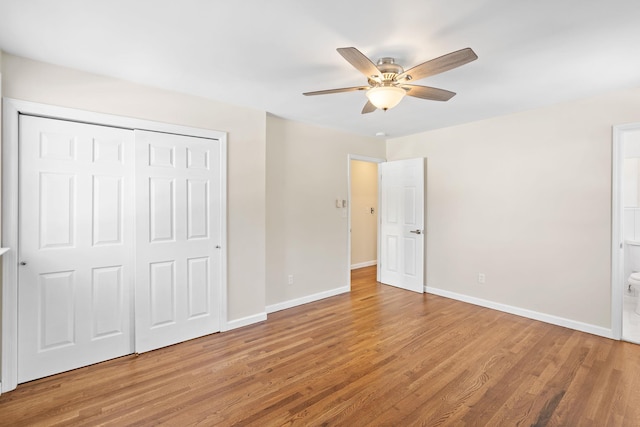 unfurnished bedroom with connected bathroom, wood-type flooring, a closet, and ceiling fan