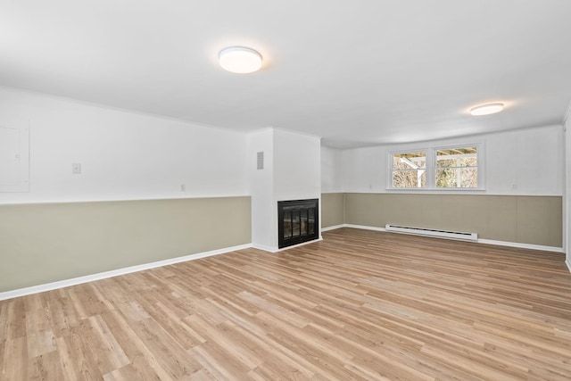 basement with light wood-type flooring and baseboard heating