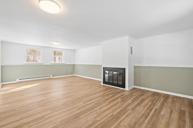 unfurnished living room with a multi sided fireplace, light hardwood / wood-style flooring, and a baseboard heating unit