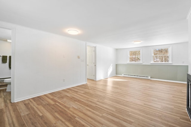 spare room with light wood-type flooring and a baseboard heating unit