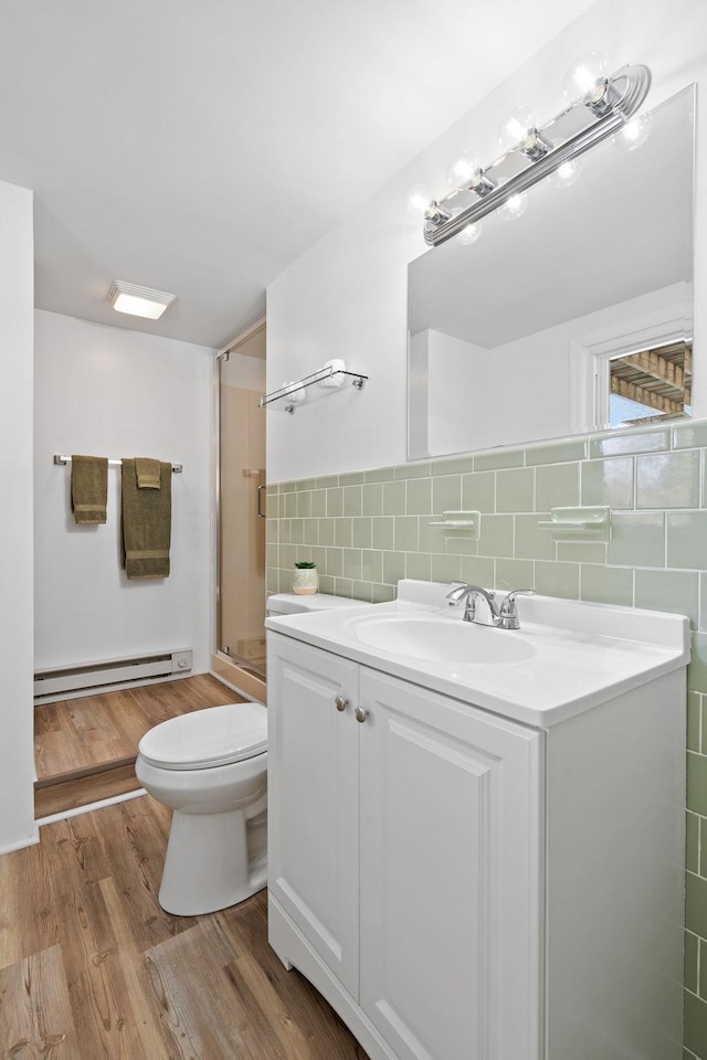 bathroom featuring walk in shower, toilet, tile walls, a baseboard radiator, and vanity