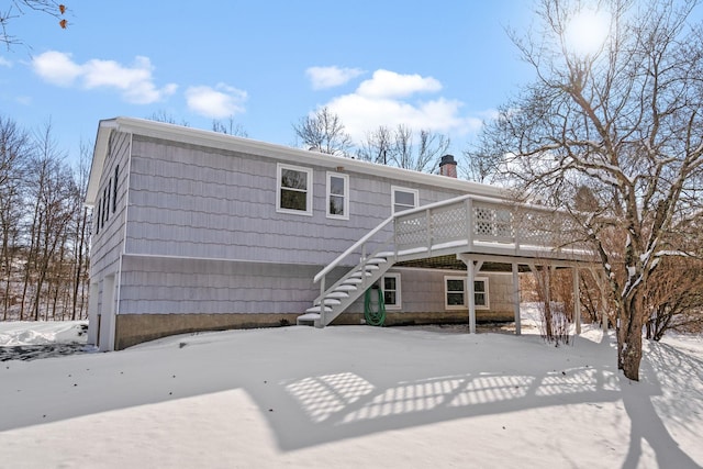 snow covered house with a wooden deck