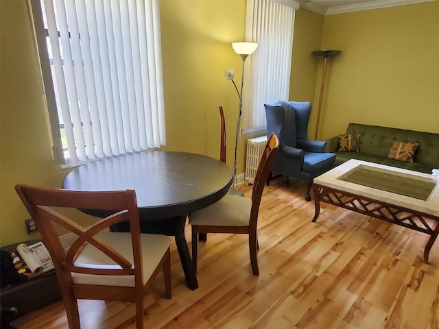 dining room featuring light wood-style flooring and ornamental molding