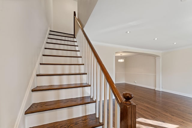 staircase with hardwood / wood-style floors and crown molding