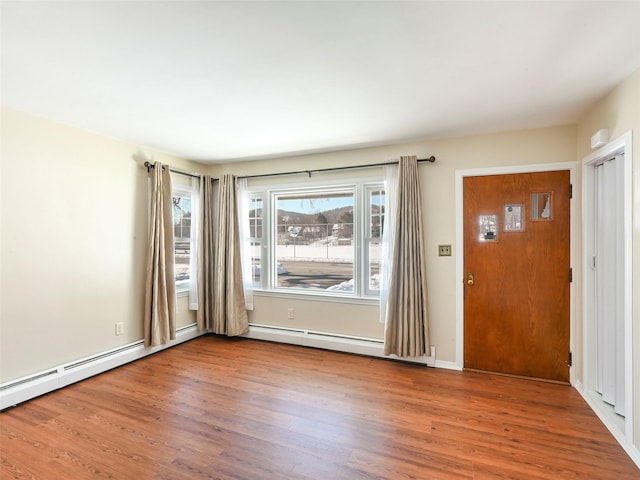 foyer entrance featuring wood-type flooring and a baseboard radiator