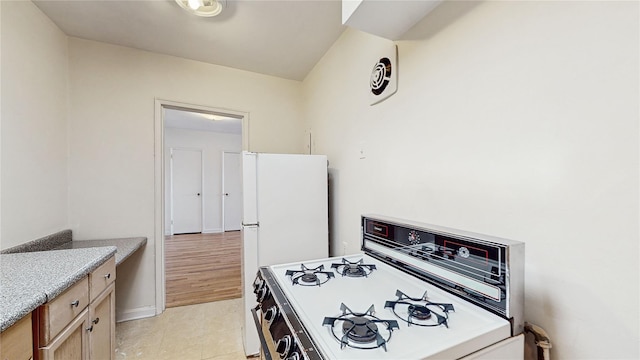 kitchen with white appliances, light tile patterned flooring, and light brown cabinets