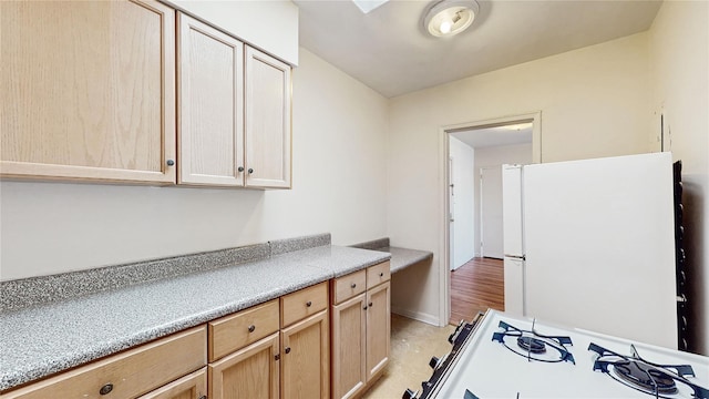 kitchen with white appliances and light brown cabinetry