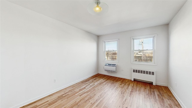 unfurnished room with radiator and light hardwood / wood-style floors