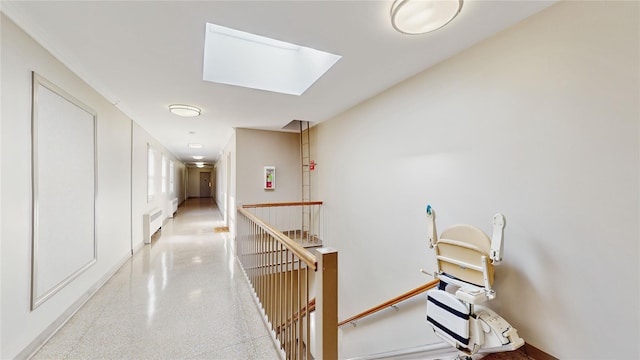 hallway with radiator heating unit and a skylight