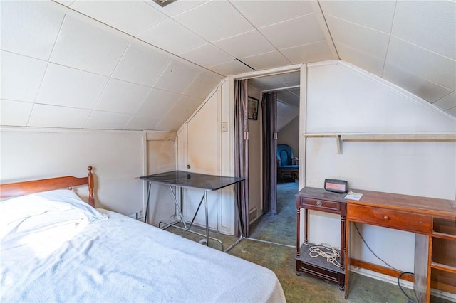 bedroom featuring lofted ceiling and dark carpet