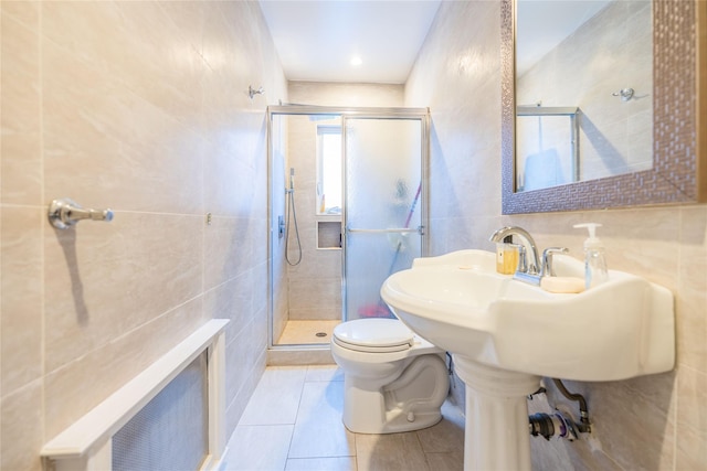 bathroom featuring tile walls, backsplash, tile patterned flooring, toilet, and a shower with door