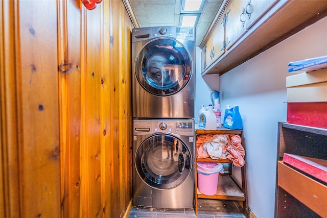 washroom with stacked washer and dryer, dark hardwood / wood-style floors, and cabinets