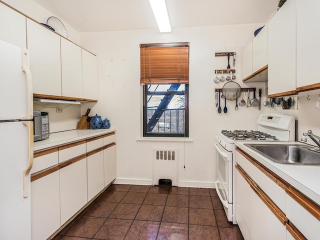 kitchen featuring radiator, white appliances, sink, and white cabinets