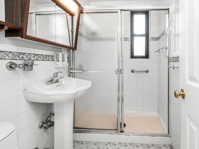 bathroom with tile walls, an enclosed shower, and toilet