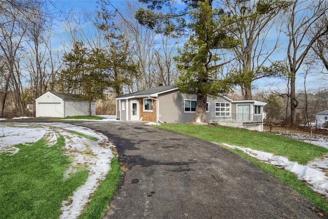 ranch-style house with a garage, an outdoor structure, and a front lawn