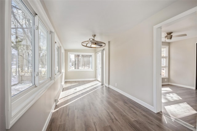 unfurnished sunroom with plenty of natural light and ceiling fan