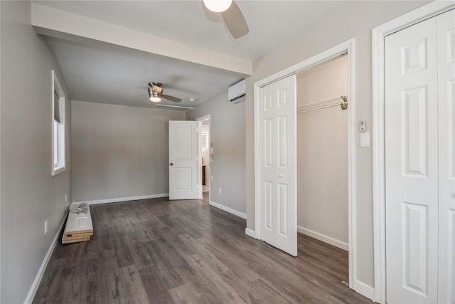 unfurnished bedroom featuring a wall mounted air conditioner, dark wood-type flooring, and ceiling fan