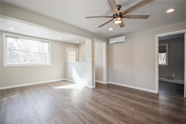 empty room featuring a wall unit AC, dark hardwood / wood-style floors, and ceiling fan