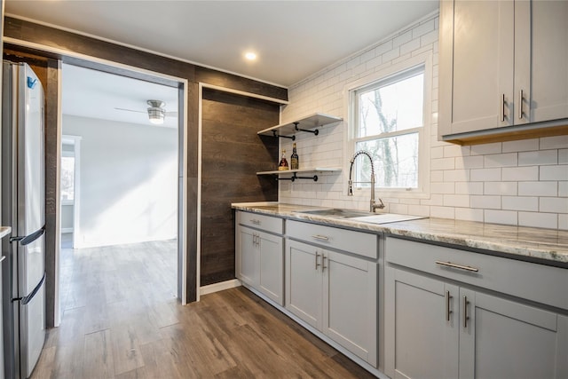 kitchen with dark hardwood / wood-style flooring, sink, gray cabinets, and stainless steel refrigerator