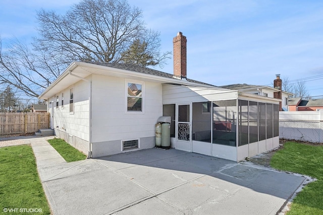 rear view of house with a patio area and a sunroom