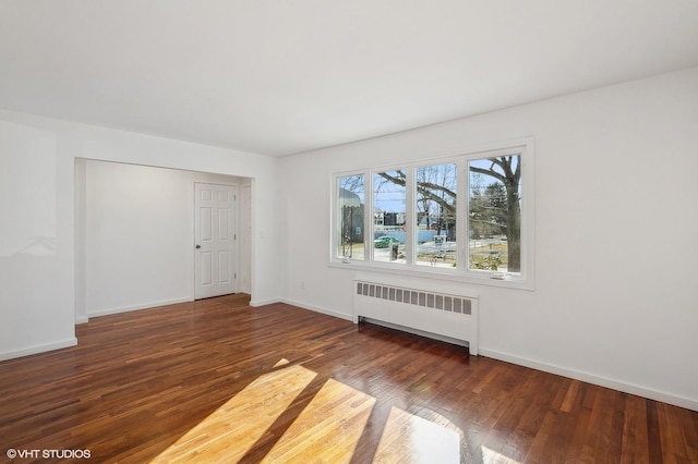 unfurnished room with dark wood-type flooring and radiator heating unit