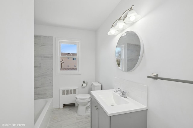 bathroom featuring vanity, radiator, a washtub, and toilet