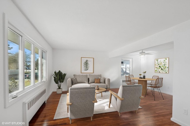 living area with radiator, baseboards, and wood finished floors