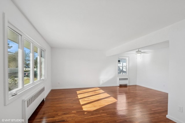 unfurnished room featuring radiator heating unit, baseboards, and wood finished floors