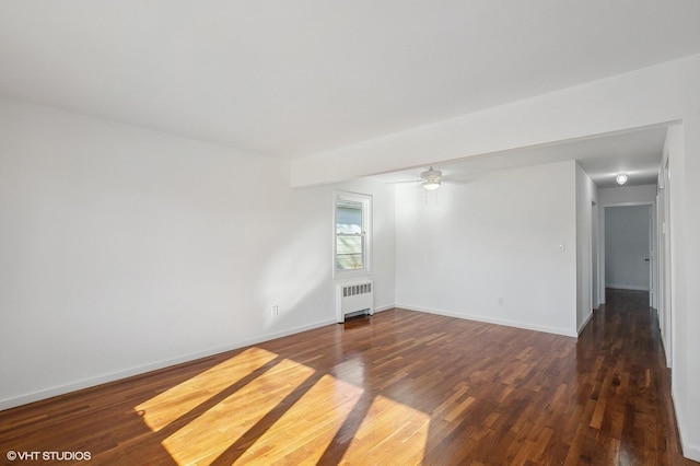 spare room with a ceiling fan, baseboards, radiator heating unit, and wood finished floors