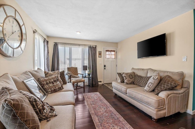 living room with dark hardwood / wood-style flooring, a textured ceiling, and a baseboard heating unit