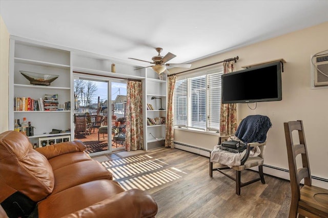 sitting room with a wall mounted AC, hardwood / wood-style floors, and ceiling fan