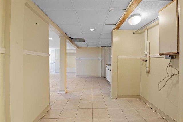 hall with light tile patterned floors and a drop ceiling