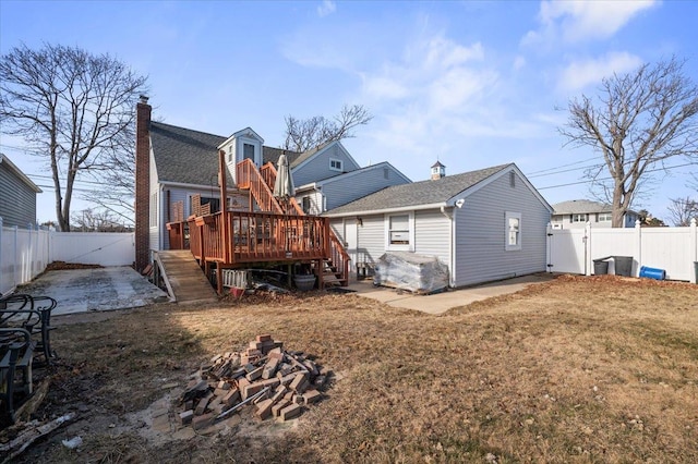 back of house featuring a wooden deck, a fire pit, a patio area, and a lawn