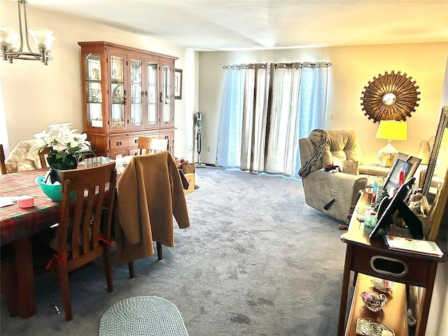 dining area featuring an inviting chandelier and dark carpet