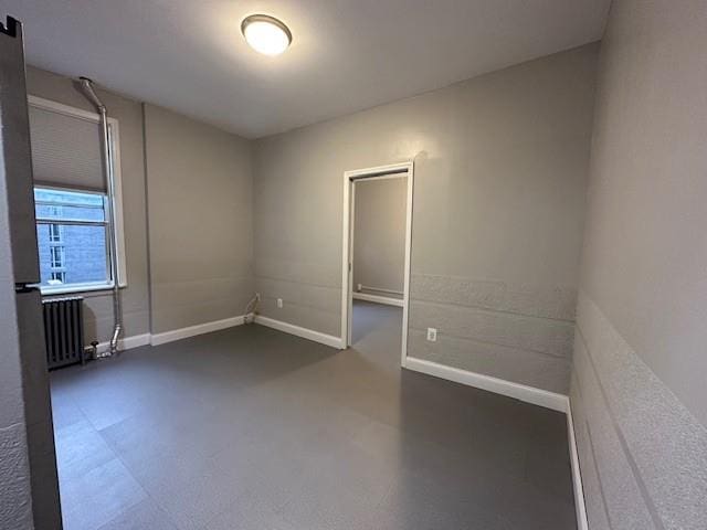 unfurnished room featuring radiator heating unit