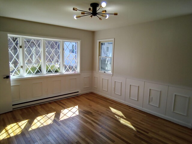 129 Franklin Ave, Monroe, NY 10950 - unfurnished room with wood-type flooring, an inviting chandelier, and baseboard heating