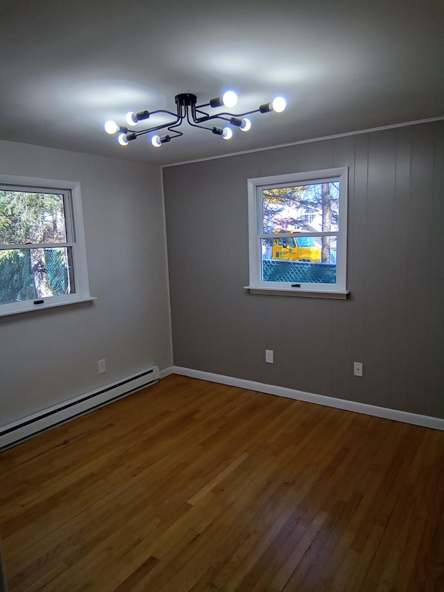 129 Franklin Ave, Monroe, NY 10950 - unfurnished room featuring an inviting chandelier, hardwood / wood-style floors, and a baseboard heating unit