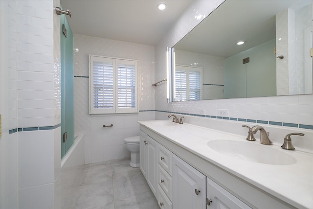 full bathroom with shower / tub combination, vanity, toilet, and tile walls