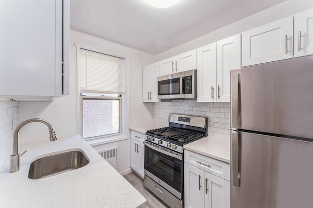 kitchen featuring light stone counters, sink, white cabinets, and appliances with stainless steel finishes