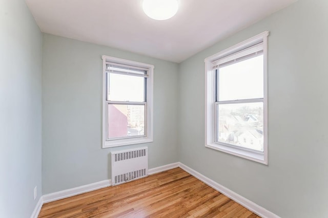 spare room with radiator and light wood-type flooring