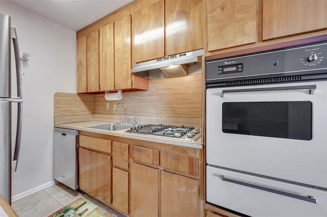 kitchen featuring stainless steel appliances, sink, light tile patterned floors, and decorative backsplash