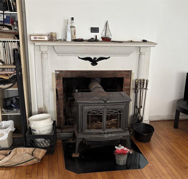 room details with hardwood / wood-style flooring and a wood stove