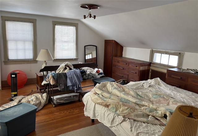 bedroom featuring multiple windows, lofted ceiling, and dark hardwood / wood-style floors
