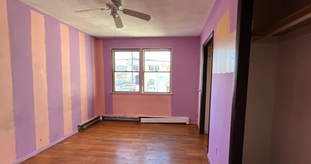 spare room featuring hardwood / wood-style flooring, ceiling fan, and baseboard heating