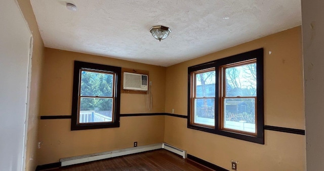 unfurnished room with dark hardwood / wood-style flooring, a wall mounted air conditioner, a baseboard radiator, and a textured ceiling