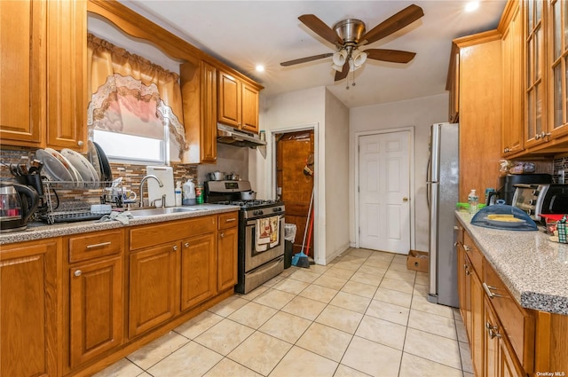 kitchen featuring light stone counters, sink, decorative backsplash, and appliances with stainless steel finishes