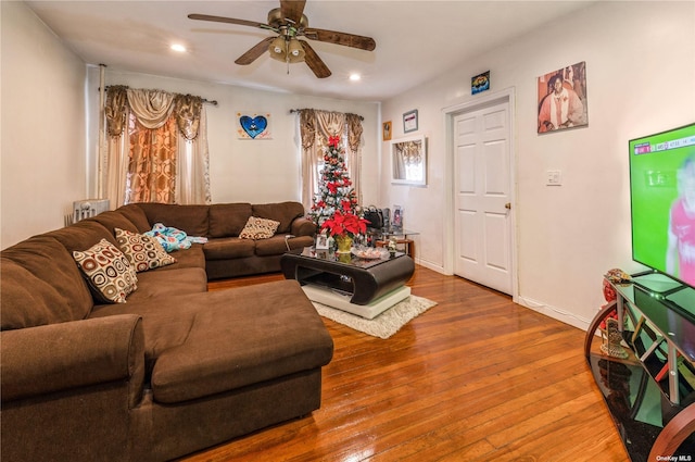 living room featuring wood-type flooring and ceiling fan