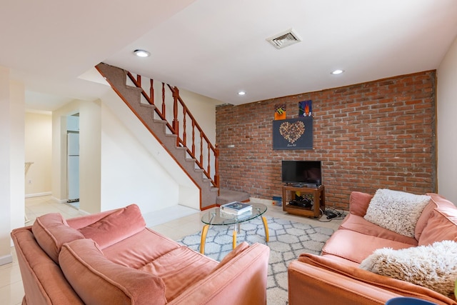 tiled living room featuring brick wall